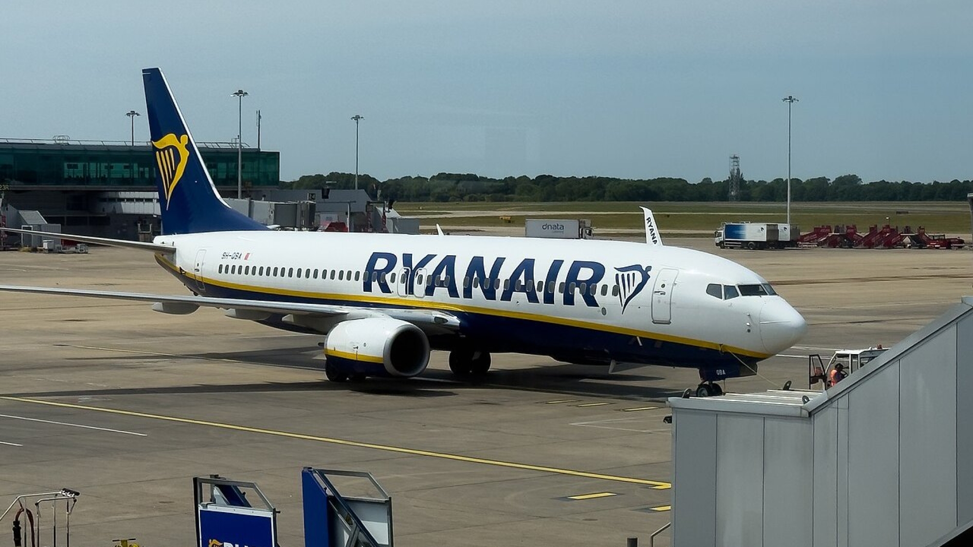 Boeing 737 společnosti Ryanair stojí u nástupního mostu na odbavovací ploše letiště