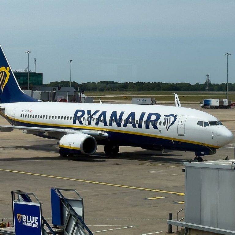 Boeing 737 společnosti Ryanair stojí u nástupního mostu na odbavovací ploše letiště