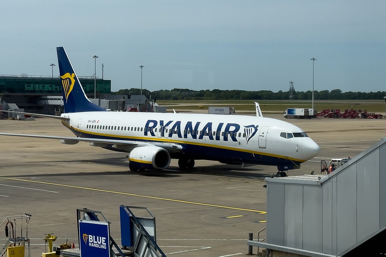 Boeing 737 společnosti Ryanair stojí u nástupního mostu na odbavovací ploše letiště